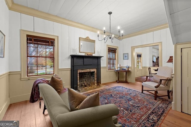 living room with a chandelier, light hardwood / wood-style flooring, and crown molding