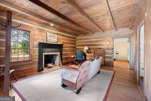 living room featuring hardwood / wood-style flooring, wooden ceiling, beamed ceiling, and a brick fireplace