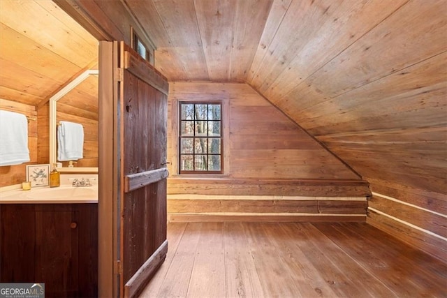 bonus room with lofted ceiling, wooden ceiling, sink, wooden walls, and hardwood / wood-style flooring