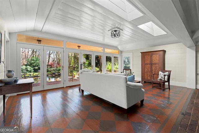 living room featuring lofted ceiling with skylight, french doors, and dark hardwood / wood-style floors