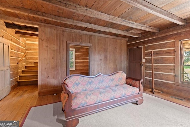 living area with beam ceiling, light hardwood / wood-style flooring, and wooden ceiling