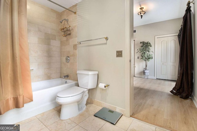 bathroom with hardwood / wood-style floors, shower / tub combo, and toilet