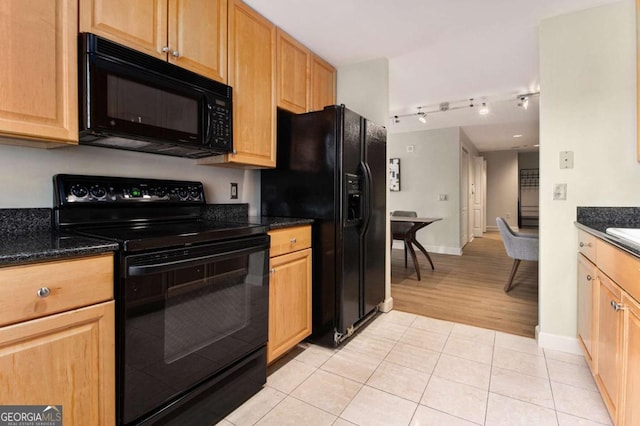 kitchen with black appliances, light tile patterned flooring, and dark stone countertops