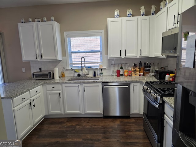 kitchen with white cabinetry, dark wood-type flooring, appliances with stainless steel finishes, and a sink