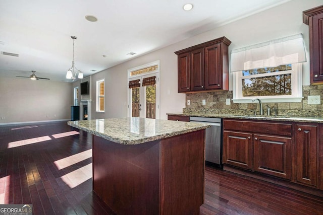 kitchen with a center island, dark hardwood / wood-style floors, stainless steel dishwasher, and sink