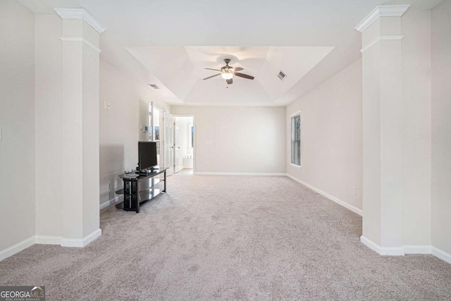 unfurnished living room featuring ceiling fan, decorative columns, carpet floors, and a tray ceiling