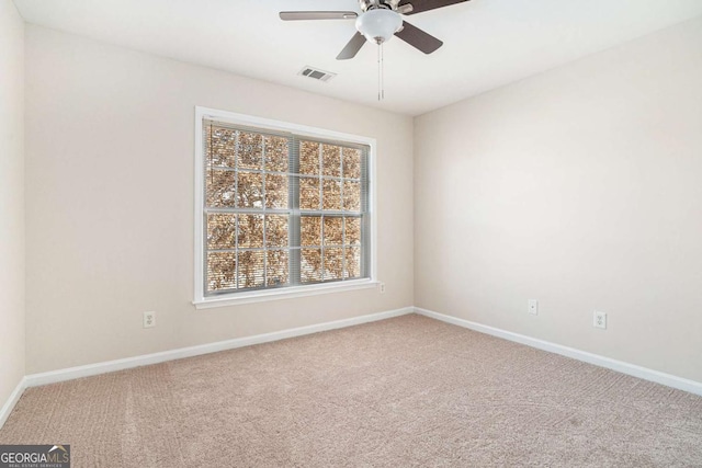 empty room featuring ceiling fan and carpet