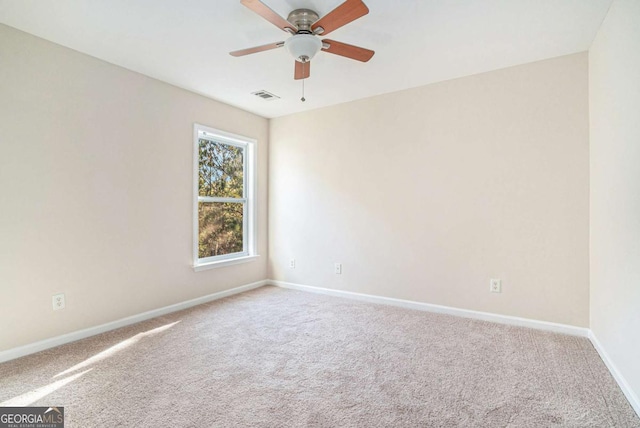 carpeted spare room with ceiling fan