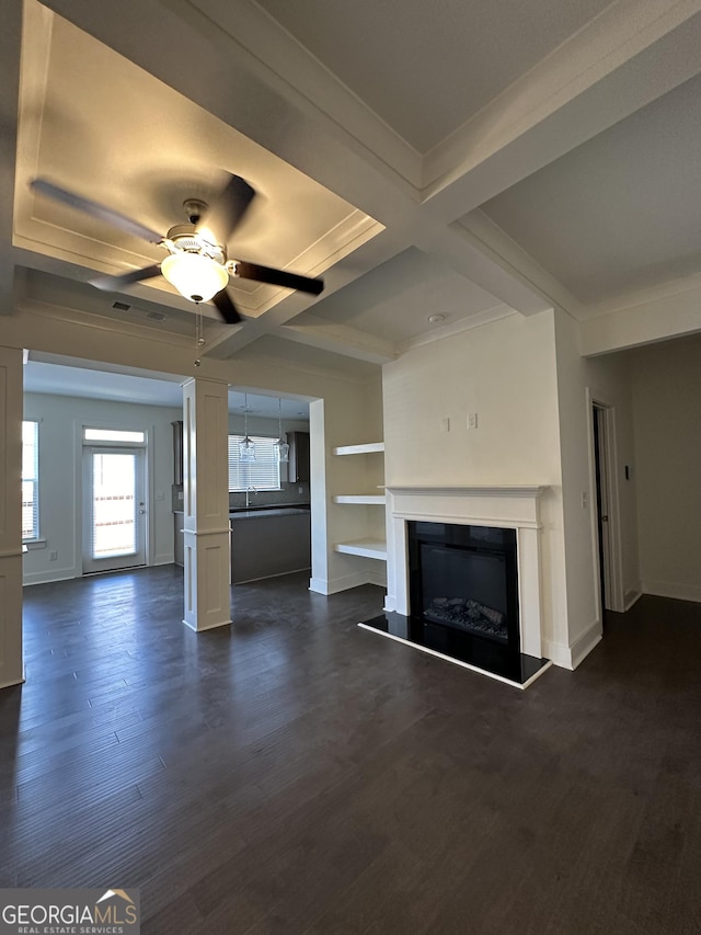 unfurnished living room featuring ceiling fan, coffered ceiling, dark hardwood / wood-style flooring, beamed ceiling, and ornamental molding