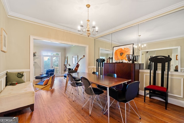 dining room featuring hardwood / wood-style flooring, french doors, crown molding, and an inviting chandelier