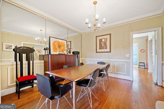 dining area with light wood-type flooring, crown molding, and a chandelier