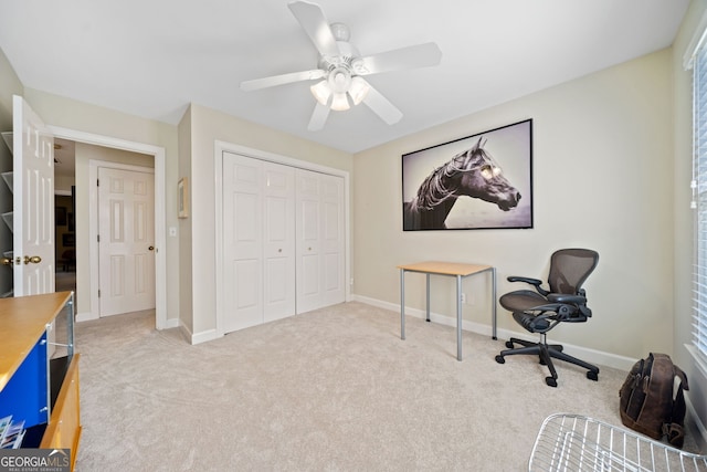 carpeted home office featuring ceiling fan