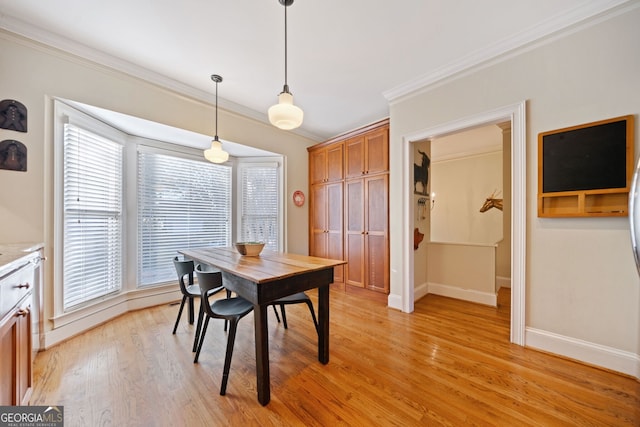 dining area featuring ornamental molding and light wood-type flooring