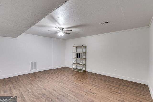 interior space with crown molding, a textured ceiling, and hardwood / wood-style flooring