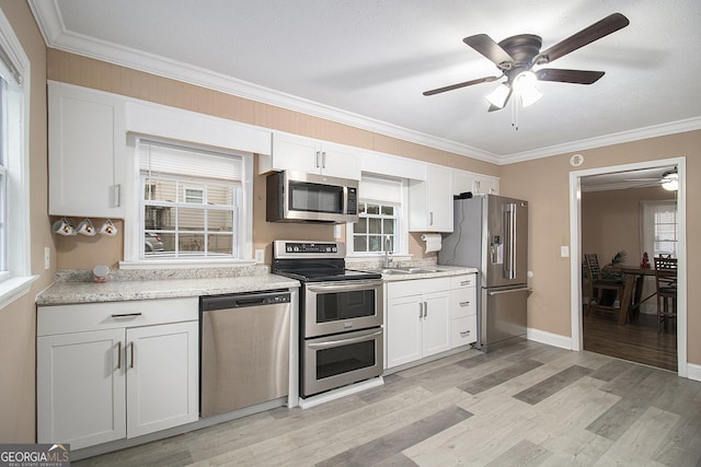 kitchen featuring white cabinets, light wood-type flooring, and stainless steel appliances