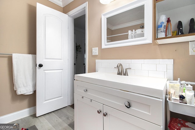 bathroom featuring decorative backsplash, crown molding, hardwood / wood-style floors, and vanity