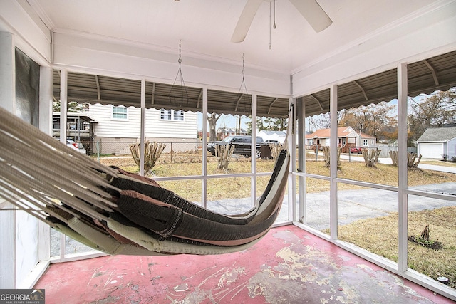 unfurnished sunroom featuring ceiling fan