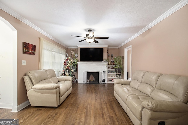 living room featuring ceiling fan, dark hardwood / wood-style flooring, crown molding, and a textured ceiling