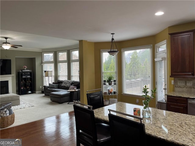 dining area with ornamental molding, light wood-type flooring, ceiling fan, and a healthy amount of sunlight