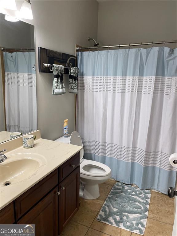 bathroom featuring tile patterned floors, vanity, and toilet