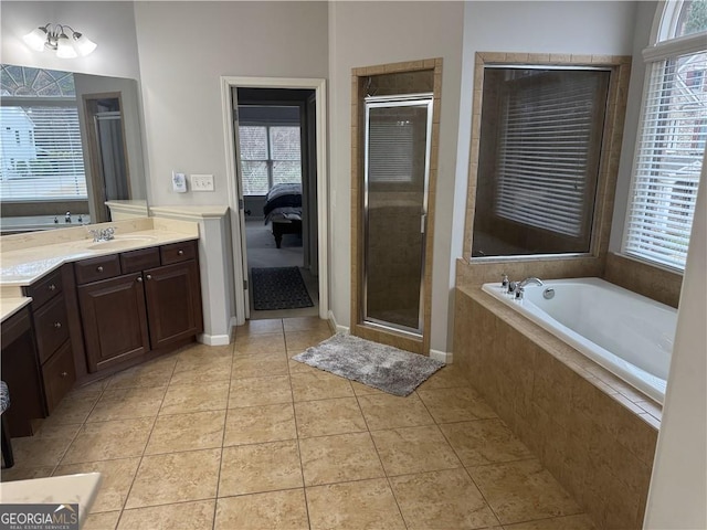 bathroom with tile patterned floors, plus walk in shower, plenty of natural light, and vanity