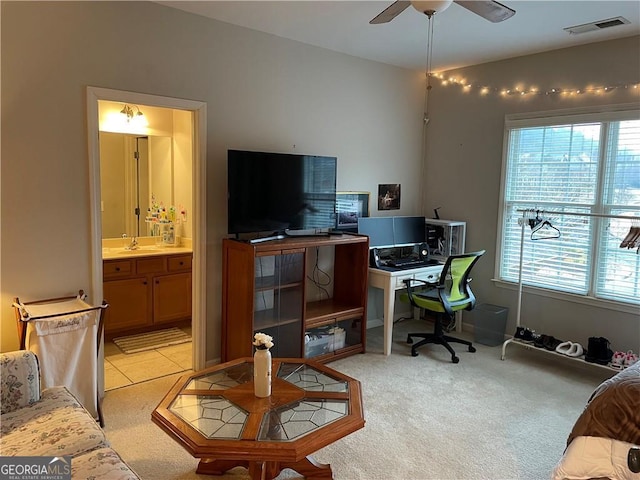 office area with light carpet, sink, and ceiling fan