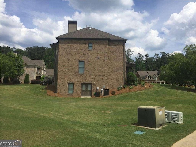 view of side of home featuring central air condition unit and a yard