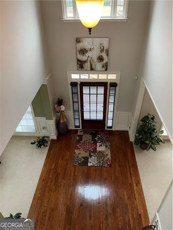 entryway with a high ceiling, dark hardwood / wood-style floors, and plenty of natural light