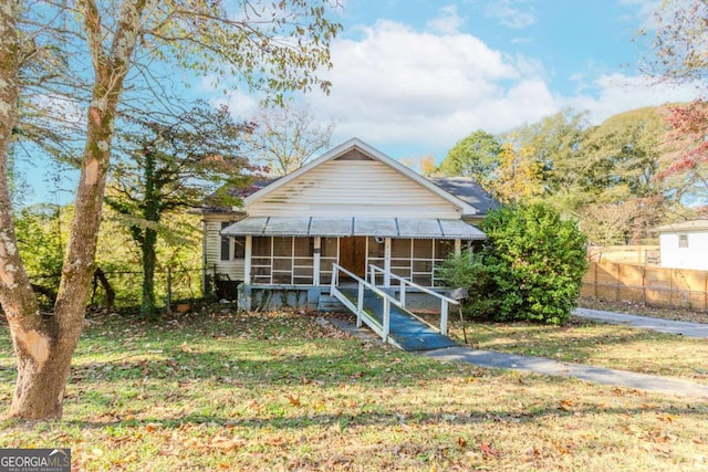 bungalow-style home with a sunroom and a front lawn