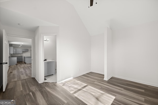 interior space with dark wood-type flooring and vaulted ceiling