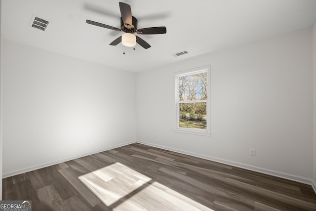 empty room with ceiling fan and dark hardwood / wood-style flooring