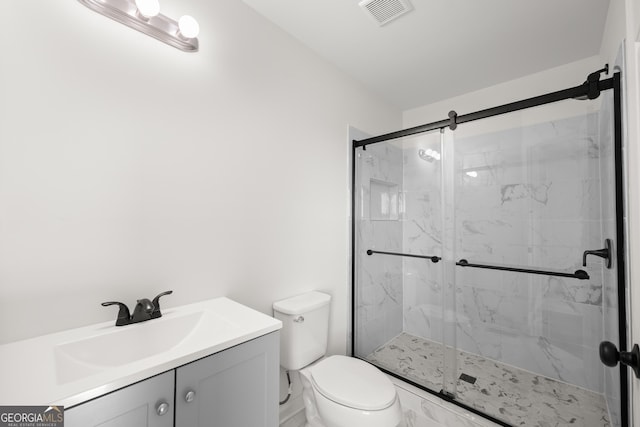 bathroom featuring vanity, toilet, and a shower with shower door