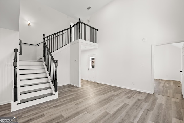 interior space with wood-type flooring and a towering ceiling