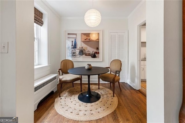 sitting room featuring ornamental molding, radiator, and dark wood-type flooring