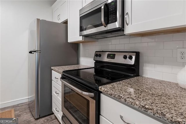 kitchen with light stone countertops, appliances with stainless steel finishes, dark hardwood / wood-style flooring, tasteful backsplash, and white cabinets