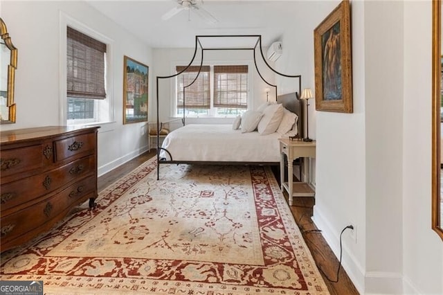 bedroom featuring ceiling fan, dark hardwood / wood-style flooring, and multiple windows