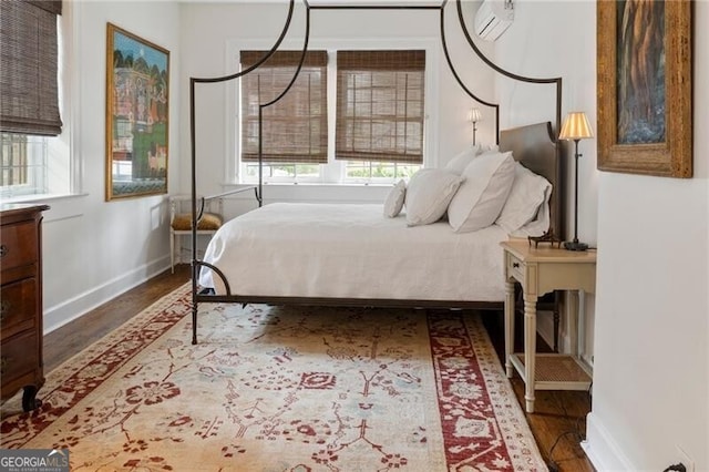 bedroom featuring a wall mounted AC and dark hardwood / wood-style floors