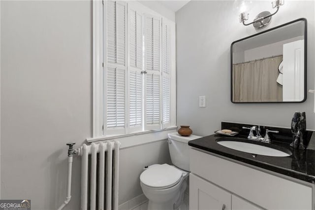 bathroom with vanity, toilet, and radiator heating unit