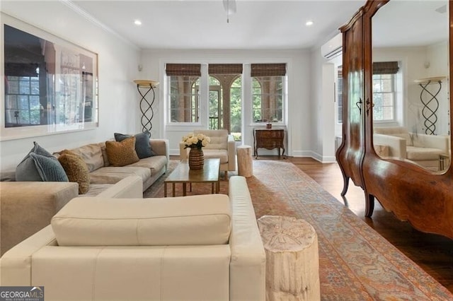 living room with dark hardwood / wood-style flooring, ornamental molding, and a wall unit AC