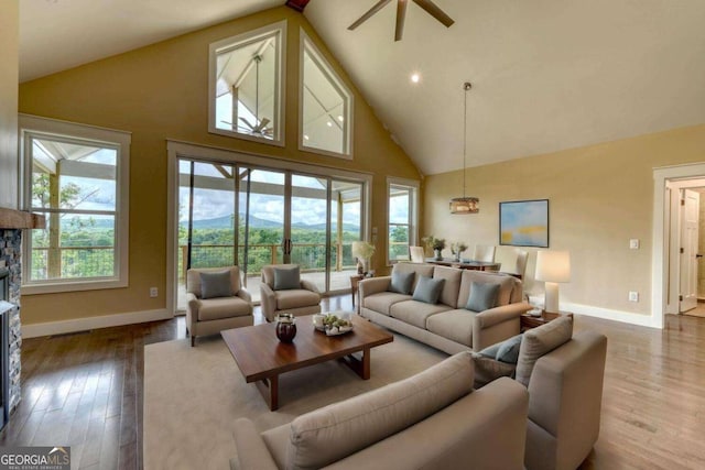 living room featuring a mountain view, wood-type flooring, high vaulted ceiling, and plenty of natural light