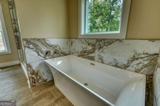 bathroom with a bathtub and a wealth of natural light