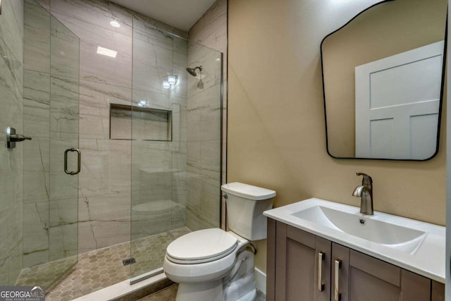 bathroom featuring vanity, toilet, and walk in shower