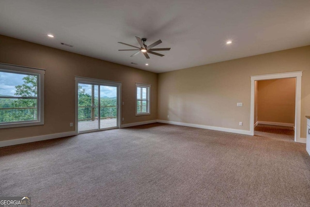 empty room featuring ceiling fan and light colored carpet