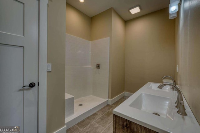 bathroom with a shower, vanity, and tile patterned flooring