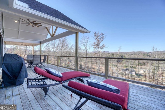 wooden terrace featuring ceiling fan and a grill