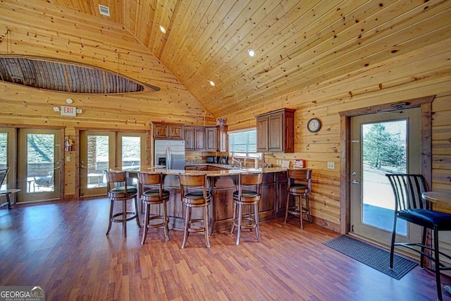 kitchen featuring stainless steel fridge, high vaulted ceiling, and a healthy amount of sunlight