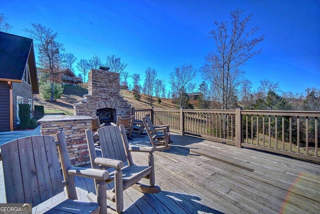 deck with an outdoor stone fireplace