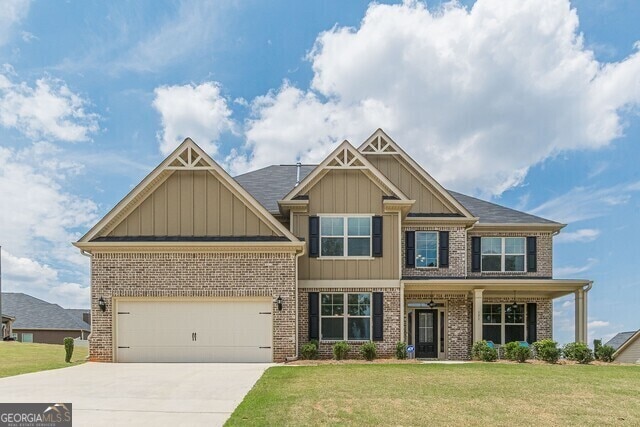 craftsman-style house featuring a garage and a front lawn