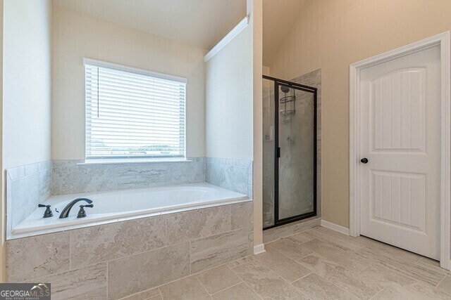 bathroom with shower with separate bathtub and lofted ceiling