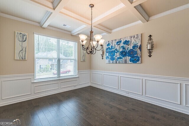 spare room with crown molding, dark wood-type flooring, and coffered ceiling